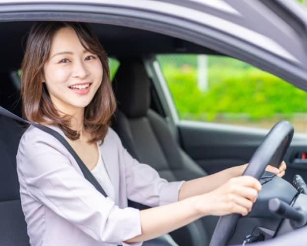 シートベルトを着用し、ハンドルを握る女性