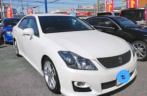 中古車販売店の展示場に並ぶ白い高級セダン